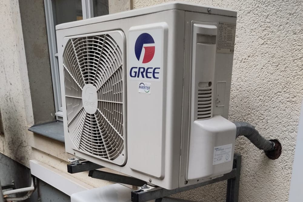 Ductless mini-split outdoor unit mounted on a wall bracket